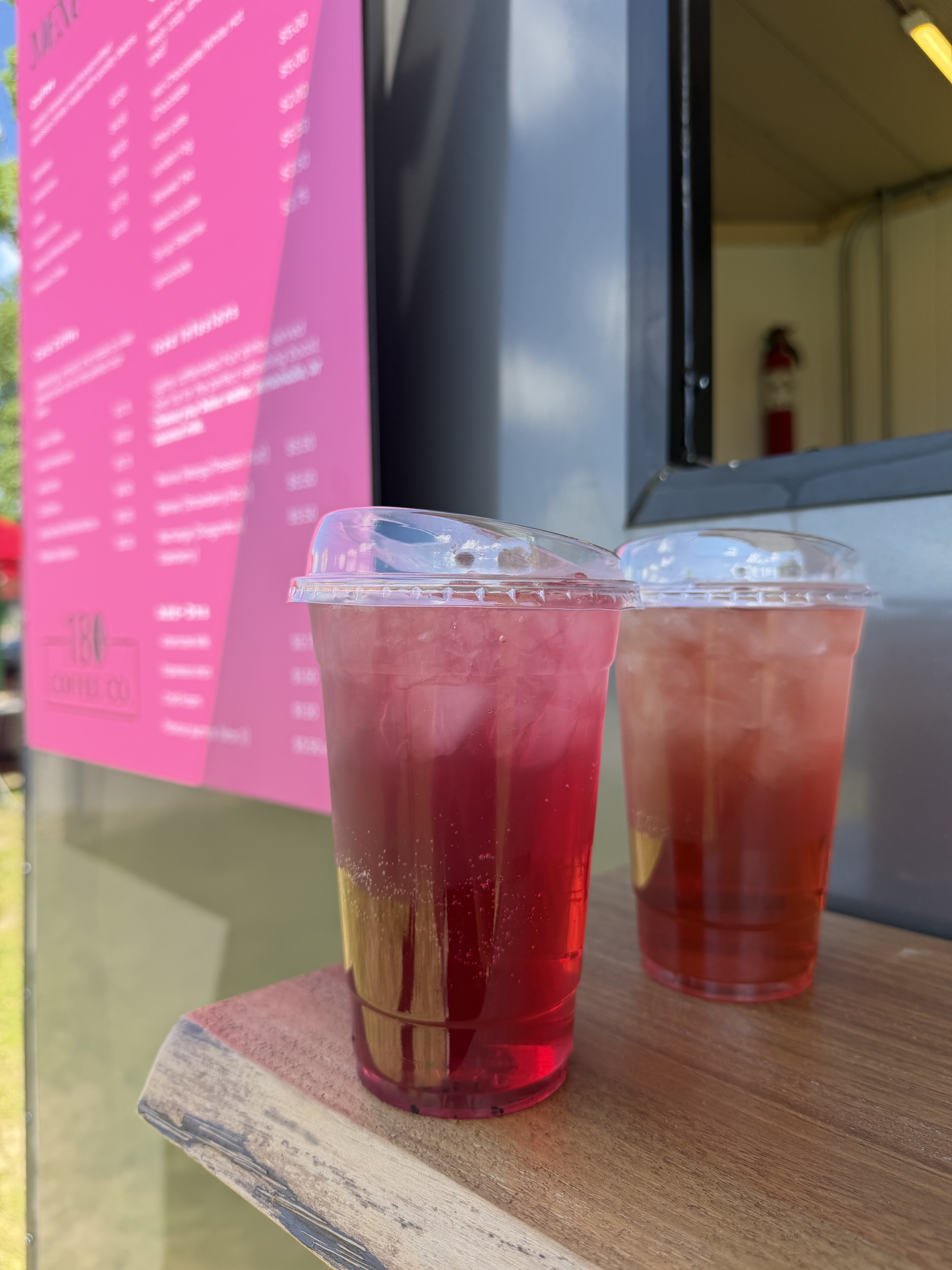 Two iced fruit infusions from 180 Coffee Co. on a wooden ledge